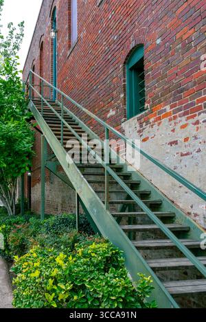 Una lunga rampa di scale corre all'esterno di un edificio in mattoni, Smithville, Texas, USA. Foto Stock