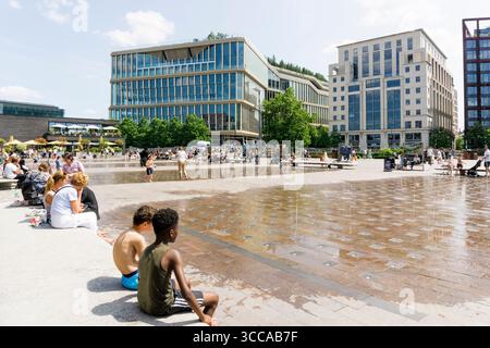 I bambini si godono le fontane di Granary Square, King's Cross, in una calda giornata estiva. Foto Stock