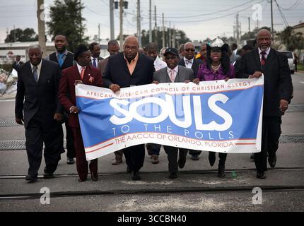 27 ottobre 2022, Stati Uniti: Il Rev. Randolph Bracy Jr., Right, e altri leader e membri della chiesa marciano lungo Kaley Street a Orlando, Florida, sulla strada per la votazione anticipata il 28 ottobre 2012. I membri di circa 20 chiese si sono riuniti all'ufficio elettorale del supervisore della contea di Orange per esprimere il loro voto in anticipo. (Immagine di credito: © Jacob Langston/Orlando Sentinel tramite ZUMA Press Wire) Foto Stock