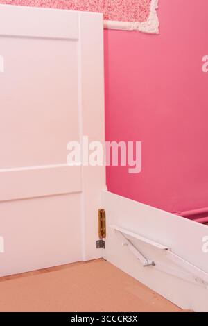 assemblare un letto in una stanza rosa Foto Stock