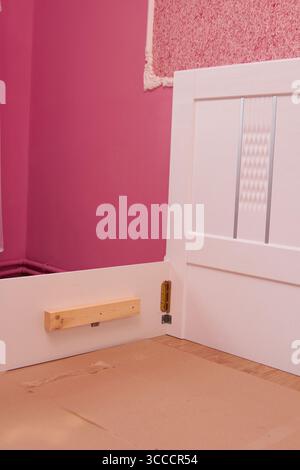 in una stanza rosa che assembla una cornice del letto bianca per una ragazza Foto Stock