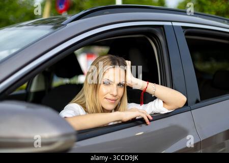 Ritratto di una donna d'affari di successo che si rilassa nella sua auto dopo aver finito la giornata di lavoro, godendosi momenti di pace e tranquillità Foto Stock