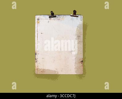 Un vecchio blocco appunti in metallo con superficie bianca invecchiata e clip arrugginite viene visualizzato su uno sfondo verde oliva Foto Stock