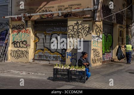 Vista sulla strada di un venditore di aglio ad Atene, in Grecia, in una giornata luminosa, che cattura la vita locale e la cultura del mercato urbano. Foto Stock
