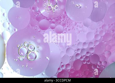 Un insolito sfondo astratto in tonalità rosa e lilla, imitando macchie di olio sulla superficie dell'acqua. La miscela stravagante di lilla oi rosa e morbida Foto Stock
