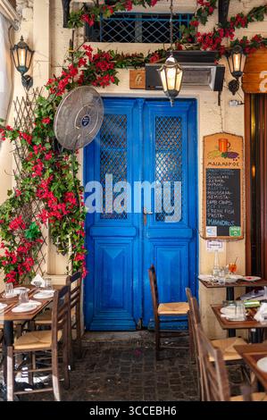 Ingresso alla tradizionale taverna greca con porta Blu e fiori ad Atene Foto Stock
