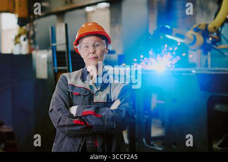 Ritratto di donna caucasica di mezza età in piedi con fiducia in fabbrica Foto Stock