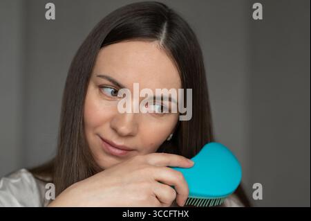 Giovane donna che si lava i capelli lunghi e dritti. Cura dei capelli a casa Foto Stock