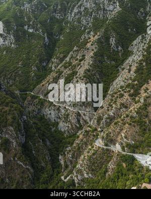 Vista aerea di una strada tortuosa che serpeggia tra le aspre e verdeggianti montagne, un arazzo di luci e ombre che dipinge le ripide pendici, Gole del Sagittario, Abruzzo, Italia. Foto Stock