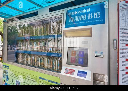 Un distributore automatico di biblioteche self-service aperto 24 ore su 24 con libri in esposizione, situato nel quartiere di Sanlitun a Chaoyang, nel centro di Pechino, in Cina, il 19 aprile Foto Stock