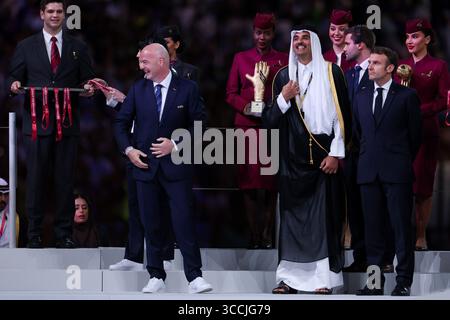 18 dicembre 2022, DOHA, QATAR: L'emiro del Qatar Tamim bin Hamad al-Thani (C) si schiera con il presidente FIFA Gianni Infantino (L) e il presidente francese Emmanuel Macron (R) dopo la finale di calcio del Qatar 2022 tra Argentina e Francia allo stadio Lusail di Lusail, a nord di Doha, il 18 dicembre 2022. (Immagine di credito: © William Volcov/ZUMA Press Wire) Foto Stock