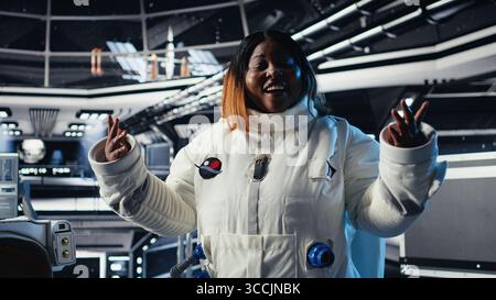 Le onde dell'astronauta giocherellono durante la videocall con il centro di comando della Terra, documentando i risultati degli esperimenti spaziali. Il cosmonauta saluta il team del centro di terra, condividendo osservazioni di ricerca Foto Stock