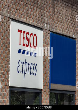 LONDRA, Regno Unito - 5 AGOSTO 2025 - cartellonistica Tesco Express esposta su una parete di mattoni a Londra, che mostra la presenza del marchio nel Regno Unito Foto Stock