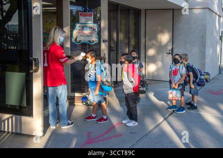 2 ottobre 2020: Con un termometro digitale, un'insegnante di scuola elementare della California controlla le temperature degli studenti in arrivo multirazziali al loro arrivo per la lezione (Credit Image: © Spencer Grant/ZUMA Press Wire) Foto Stock