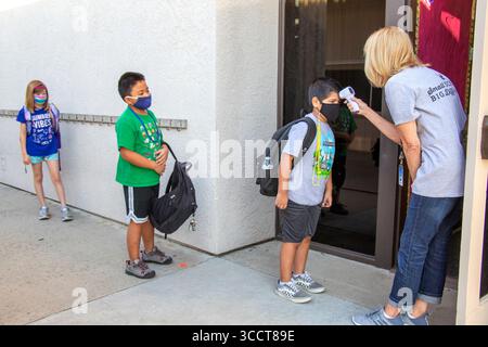 2 ottobre 2020: Con un termometro digitale, un'insegnante di scuola elementare della California controlla le temperature degli studenti in arrivo multirazziali al loro arrivo per la lezione (Credit Image: © Spencer Grant/ZUMA Press Wire) Foto Stock
