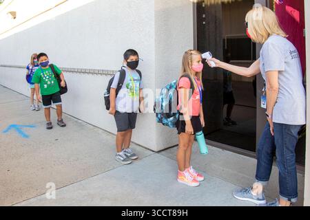 2 ottobre 2020: Con un termometro digitale, un'insegnante di scuola elementare della California controlla le temperature degli studenti in arrivo multirazziali al loro arrivo per la lezione (Credit Image: © Spencer Grant/ZUMA Press Wire) Foto Stock