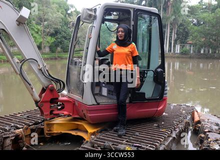 11 ottobre 2022, Giacarta, Giacarta, INDONESIA: Rani , 40 anni quando lavora come operatore di attrezzature pesanti, di solito fatto da uomini al parco Dadap Merah, Lenteng Agung, Giacarta, il 20 ottobre 2022. Rani è una donna che sceglie di essere un operatore di escavatori che lavora a tempo pieno per pulire i rifiuti del fiume Giacarta presso l'unità di gestione della pulizia (UPK) del DKI Jakarta Provincial Environment Service. Per trasportare la spazzatura nel fiume che la detiene e Rani deve essere pronto 24 ore su 24 quando gli viene chiesto di lavorare, perché ci sono pochissimi operatori di attrezzature pesanti e Rani è l'unica donna di attrezzature pesanti ope Foto Stock