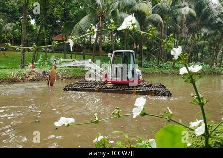 11 ottobre 2022, Giacarta, Giacarta, INDONESIA: Rani , 40 anni quando lavora come operatore di attrezzature pesanti, di solito fatto da uomini al parco Dadap Merah, Lenteng Agung, Giacarta, il 20 ottobre 2022. Rani è una donna che sceglie di essere un operatore di escavatori che lavora a tempo pieno per pulire i rifiuti del fiume Giacarta presso l'unità di gestione della pulizia (UPK) del DKI Jakarta Provincial Environment Service. Per trasportare la spazzatura nel fiume che la detiene e Rani deve essere pronto 24 ore su 24 quando gli viene chiesto di lavorare, perché ci sono pochissimi operatori di attrezzature pesanti e Rani è l'unica donna di attrezzature pesanti ope Foto Stock
