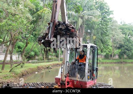 11 ottobre 2022, Giacarta, Giacarta, INDONESIA: Rani , 40 anni quando lavora come operatore di attrezzature pesanti, di solito fatto da uomini al parco Dadap Merah, Lenteng Agung, Giacarta, il 20 ottobre 2022. Rani è una donna che sceglie di essere un operatore di escavatori che lavora a tempo pieno per pulire i rifiuti del fiume Giacarta presso l'unità di gestione della pulizia (UPK) del DKI Jakarta Provincial Environment Service. Per trasportare la spazzatura nel fiume che la detiene e Rani deve essere pronto 24 ore su 24 quando gli viene chiesto di lavorare, perché ci sono pochissimi operatori di attrezzature pesanti e Rani è l'unica donna di attrezzature pesanti ope Foto Stock