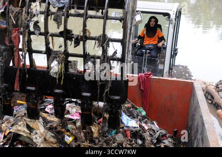 11 ottobre 2022, Giacarta, Giacarta, INDONESIA: Rani , 40 anni quando lavora come operatore di attrezzature pesanti, di solito fatto da uomini al parco Dadap Merah, Lenteng Agung, Giacarta, il 20 ottobre 2022. Rani è una donna che sceglie di essere un operatore di escavatori che lavora a tempo pieno per pulire i rifiuti del fiume Giacarta presso l'unità di gestione della pulizia (UPK) del DKI Jakarta Provincial Environment Service. Per trasportare la spazzatura nel fiume che la detiene e Rani deve essere pronto 24 ore su 24 quando gli viene chiesto di lavorare, perché ci sono pochissimi operatori di attrezzature pesanti e Rani è l'unica donna di attrezzature pesanti ope Foto Stock