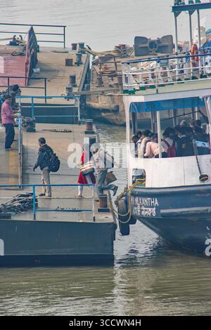 KOLKATA, BENGALA OCCIDENTALE, INDIA - 14 FEBBRAIO 2024 terminal dei traghetti Chandpal o Babughat navi di lavoro passeggeri sul fiume Hooghly o Ganga su una m grigia Foto Stock