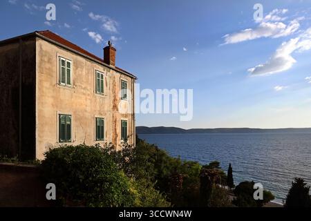 Monastero francescano di Santa Croce con strette persiane di fronte al mare Adriatico e all'isola di Hvar a Živogošće vicino a Igrane sulla costa dalmata Foto Stock