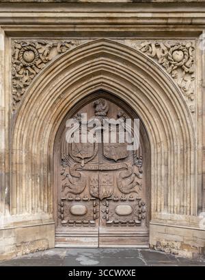 La porta in legno intagliato splendidamente ornata o l'abbazia di Bath in Inghilterra Foto Stock