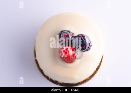 Torta bianca ricoperta di frutti di bosco e panna Foto Stock