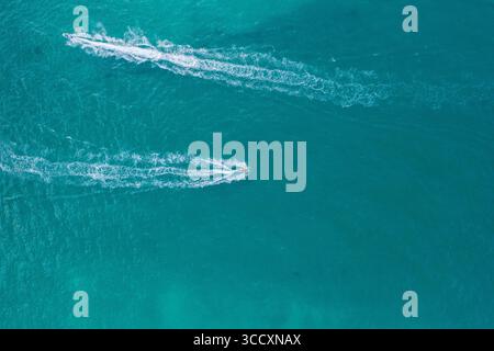 Vista aerea di due moto d'acqua che attraversano le acque turchesi, lasciando bianchi risvegli mentre attraversano il mare, Miami Beach, Florida, Stati Uniti. Foto Stock
