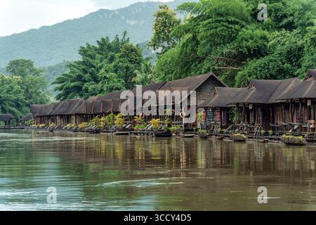 Scenografico resort in legno sul fiume kwai, circondato da una lussureggiante foresta tropicale a Kanchanaburi, Thailandia Foto Stock