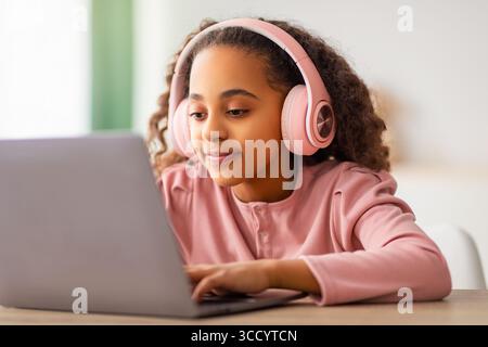 Concetto di e-learning. Ragazza afroamericana che studia online con un portatile, impara a casa Foto Stock
