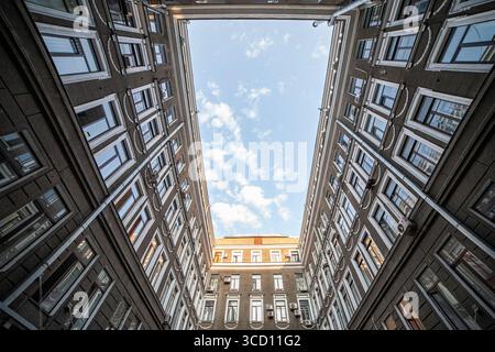 Affacciato su di un'alta apertura rettangolare in uno storico cortile di un edificio in mattoni Foto Stock