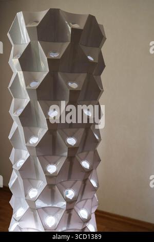 Innovativa torre idroponica verticale con luci blu, struttura geometrica illuminante che mette in risalto l'innovativa tecnologia agricola per interni Foto Stock