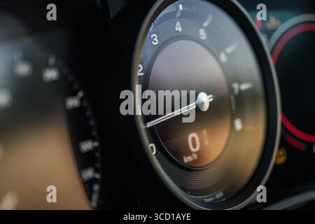 Vista ravvicinata del tachimetro e del cruscotto, che mostra dettagli precisi della strumentazione della vettura di lusso mentre la luce solare si riflette sulla superficie. Foto Stock