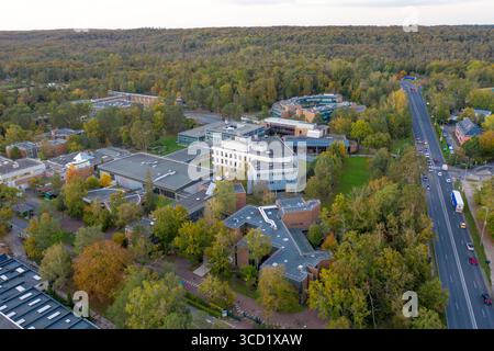 Fontainebleau, Francia - 22 ottobre 2024: Veduta aerea degli edifici della INSEAD Business School annidati tra vibranti alberi autunnali, contrastati dalla strada lineare e dalla lontana foresta. Foto Stock