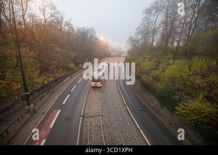 Un tram a Praga in un giorno nebuloso con vista da un ponte Foto Stock