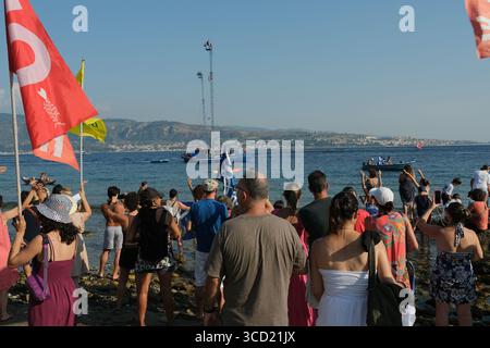 I dimostranti accolgono con favore l'arrivo delle tradizionali barche da pesca conosciute come feluche, navigando con le bandiere "No Ponte". La protesta fa parte del movimento che si oppone alla costruzione del ponte sullo stretto di Messina. Foto Stock
