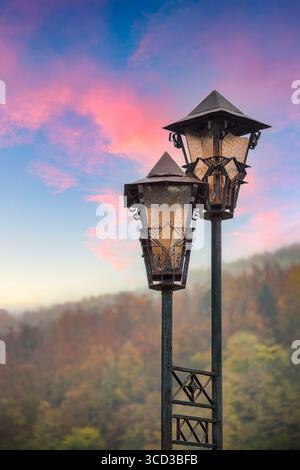 Splendida vista della vecchia lanterna di lampioni antichi d'epoca sul luminoso sole della sera e sul vivido cielo al tramonto Foto Stock