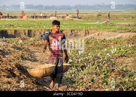 18 dicembre 2022 - il vasaio del popolo del Bangladesh porta i suoi vasi di ceramica di terra per la vendita nel mercato locale attraverso una strada del villaggio oggi. Foto Stock