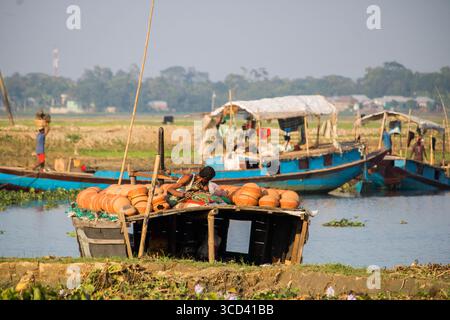 18 dicembre 2022 - il vasaio del popolo del Bangladesh porta i suoi vasi di ceramica di terra per la vendita nel mercato locale attraverso una strada del villaggio oggi. Foto Stock