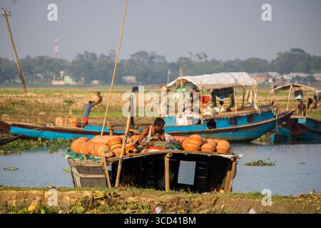 18 dicembre 2022 - il vasaio del popolo del Bangladesh porta i suoi vasi di ceramica di terra per la vendita nel mercato locale attraverso una strada del villaggio oggi. Foto Stock