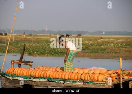18 dicembre 2022 - il vasaio del popolo del Bangladesh porta i suoi vasi di ceramica di terra per la vendita nel mercato locale attraverso una strada del villaggio oggi. Foto Stock