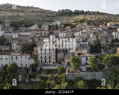 Veduta aerea del soleggiato borgo medievale di Rocca Calascio arroccato sulla ripida collina, un arazzo di antichi edifici in pietra sotto un vasto cielo, Rocca Calascio, Abruzzo, Italia. Foto Stock