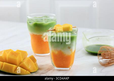 Primo piano del latte Matcha di mango Iced fatto in casa sul tavolo bianco Foto Stock