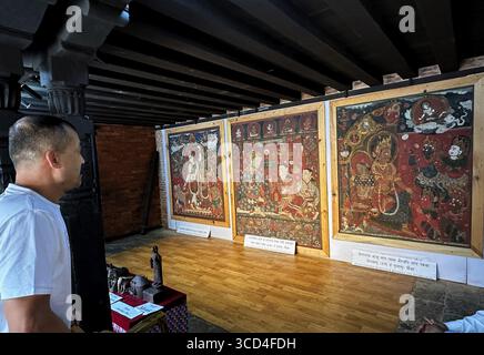 12 agosto 2025: Un visitatore osserva i tre sacri dipinti murali Paubha esposti presso il museo di Keshchandra Mahavihar a Itumbahal, Kathmandu il 12 agosto 2025. Le opere d'arte includono una 300 raffigurazione di Chintamani Lokeshwar, un dipinto di 575 anni con Gagan Singh Bharo e sua moglie; e una rappresentazione di 321 anni di Bhairava con Keshachandra, rubata quasi 45 anni fa, sono stati recentemente rimpatriati dagli Stati Uniti in Nepal, segnando un momento significativo nella conservazione del patrimonio culturale della nazione. (Credit Image: © Sunil Sharma/ZUMA Press Wire) EDITORIALE U Foto Stock