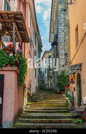 Scalinata in pietra che si snoda tra le strette e medievali strade di Arpino, rivelando edifici colorati e scorci nella storica città italiana. Arpino, Lazio Foto Stock