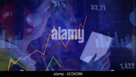 Analisi di una donna che indossa le cuffie rosse che guarda un tablet bianco nello spazio di lavoro, tabelle di mercato, spazio di copia Foto Stock