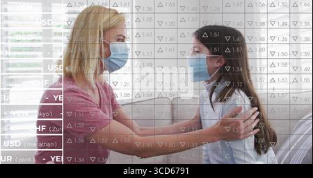 Madre e figlia sedute che indossano maschere l'una di fronte all'altra sul divano di casa, con copertura valutaria Foto Stock