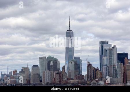 Vista dello skyline di Manhattan dal traghetto Liberty Island, New York City, USA, con grattacieli, lungomare, e lo skyline urbano in lontananza Foto Stock