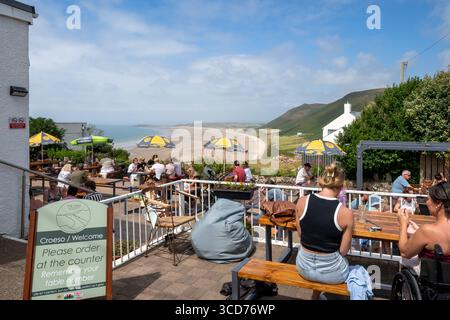The View, caffè e bar affollati con persone sedute a tavoli esterni che si affacciano su Rhossili Bay Beach, Rhossili, Gower Peninsula, Galles del Sud, Regno Unito Foto Stock